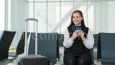 戴着笔记本电脑、手机和行李坐在机场微笑的亚洲女商人的侧面肖像。 <strong>终点</strong>站铁路